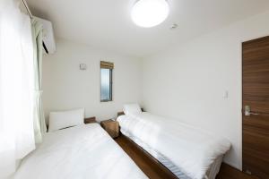 Postel nebo postele na pokoji v ubytování Mukae House
