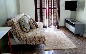a living room with a couch and a television at Casa de Benê in Tramandaí