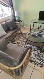 a living room with a couch and a table at Richmond Hill Guesthouse- Serviced Condo in Gqeberha
