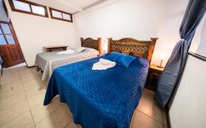 Un dormitorio con dos camas con edredón azul. en Los Faroles Zona 3, en Cobán