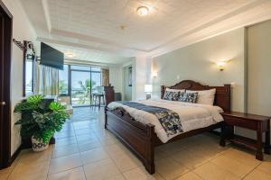 a bedroom with a large bed and a table at Paradise Jaco Beach Front in Jacó +135 photos