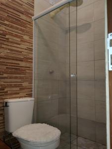 ein Badezimmer mit Toilette und Glasdusche in der Unterkunft Casa de Praia Maresias in Maresias + 43 Fotos