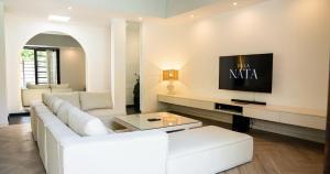 a living room with a white couch and a tv at Villa Nata Umalas in Seminyak +3 photos