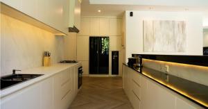 a kitchen with white counters and a black door at Villa Nata Umalas in Seminyak