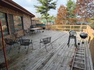 een houten terras met stoelen en een grill erop bij University Inn & Suites in Stevens Point