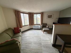 een woonkamer met een bank en een tv bij University Inn & Suites in Stevens Point