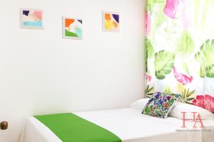 1 dormitorio con 1 cama con manta verde y blanca en Hospedaje Aldana Apartamento AURA Centro Histórico, en Tuxpan de Rodríguez Cano