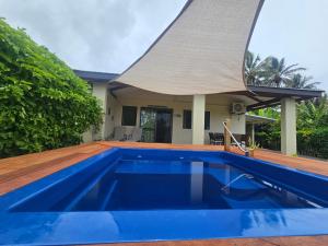 a swimming pool in front of a house at Mango Cottage with AC, Unlimited Wifi and Private pool in Rarotonga