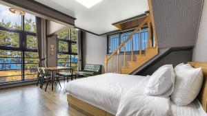 a bedroom with a bed and a table and chairs at Samcheok Lamer Pension in Samcheok