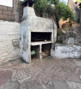 an old brick oven sitting on the side of a building at Casa zona CUCÚ de 2 dormitorios in Villa Carlos Paz