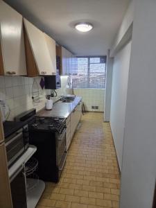 a kitchen with a stove and a tile floor at Amplio Departamento Céntrico in Barraquero