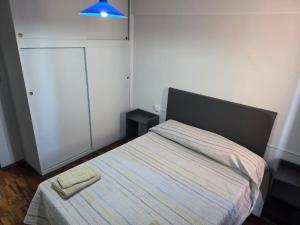 a small bedroom with a bed with a blue light at Amplio Departamento Céntrico in Barraquero