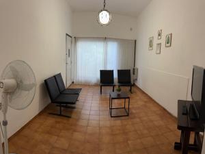 a living room with two chairs and a fan at Casa zona CUCÚ de 2 dormitorios in Villa Carlos Paz +2 photos