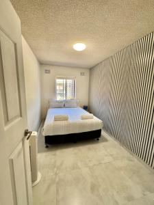 a bedroom with a bed in the corner of a room at Uninterrupted Ocean & Channel Views in The Entrance