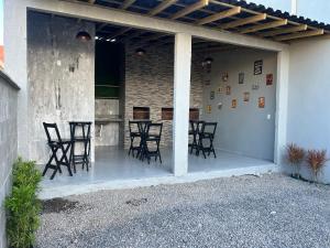 a patio with chairs and a table in a building at Havana Flats - Apto térreo 700m praia - Área Gourmet com 3 churrasqueiras in Balneário Gaivotas