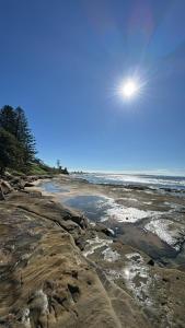 a view of a beach with the sun in the sky at Uninterrupted Ocean & Channel Views in The Entrance