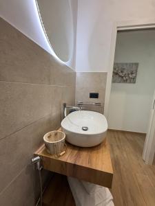 een badkamer met een witte wastafel op een houten aanrecht bij LIONS ROOMS Augusta in Augusta +43 foto's