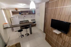 Una cocina con encimera y televisor en una habitación. en Lacqua Di Roma CNovas, en Caldas Novas