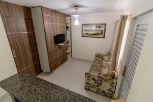 pasillo con silla y TV en una habitación en Lacqua Di Roma CNovas, en Caldas Novas