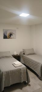 a bedroom with two beds and a light on the wall at Dpto Amoblado in Villa María