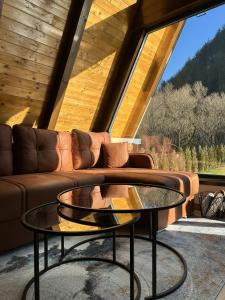 a living room with a couch and a glass table at Terra Ruj in Mokra Gora