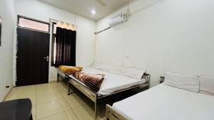 a room with two beds and a window and a door at Hardik Guest House & General Store in Rīngas