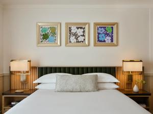 una camera da letto con un letto bianco con tre immagini sopra di Kimpton Ashbel New York Park Avenue a New York