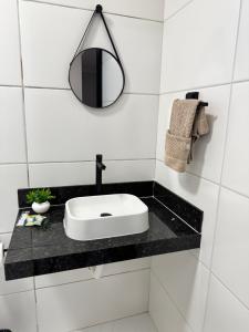 a white bathroom with a sink and a mirror at Suítes da Orla Hospedagens in Arraial do Cabo +63 photos