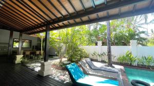 a patio with a swimming pool and a swing at The Trawangan Resort in Gili Trawangan