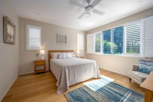 a bedroom with a bed and a couch and windows at Brunswick Lux - Close to Creek & Beach in Brunswick Heads