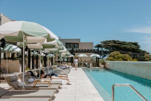 a group of people laying on lounge chairs next to a swimming pool at Hotel Sorrento in Sorrento