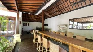 a dining room with a long wooden table and chairs at The Trawangan Resort in Gili Trawangan