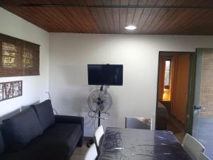 ein Wohnzimmer mit einer Couch, einem Tisch und einem Fernseher in der Unterkunft La Dominga in La Granja