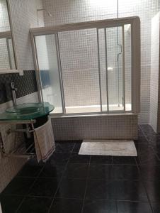 a bathroom with a shower and a sink and a window at Aires Verdes in General Pico