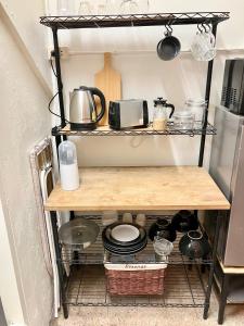 a kitchen shelf filled with pots and pans at Bang Chak Studio in Bangkok