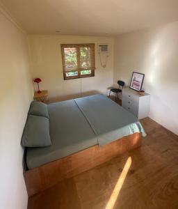een slaapkamer met een groot bed en een raam bij Surfer's Hideout in General Luna