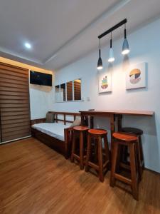 una camera con letto, tavolo e sgabelli di Upper Room Megatower III a Baguio Altre 2 foto