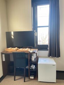 Ogaki Hiyori Hotel - Vacation STAY 70090v في أوغاكي: مكتب به كرسي أزرق ونافذة