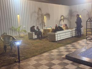 een groep mensen op banken in een kamer bij The Paradise farm stay in Ghaziabad