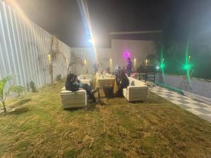 een groep mensen die op banken in het gras zitten bij The Paradise farm stay in Ghaziabad