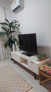 Μια τηλεόραση ή/και κέντρο ψυχαγωγίας στο Apartamento confortável no Canto do Forte