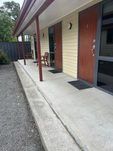 a front porch of a house with wooden doors at Woodbourne Tavern and Motel in Renwick