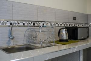 a kitchen counter with a sink and a microwave at Hotel Shumaq Yungay in Yungay