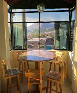 een tafel en stoelen in een kamer met een groot raam bij Hotel Shumaq Yungay in Yungay