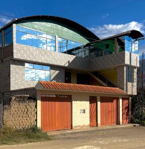 een gebouw met oranje garagedeuren en een glazen gebouw bij Hotel Shumaq Yungay in Yungay