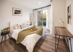 a bedroom with a bed with a table and a window at Brand New 3B2B Designer Home near SeaTac in Seattle