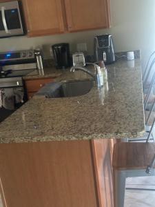 een keuken met een granieten aanrecht met een wastafel bij Maxx Maximum Comfort LLC in Orlando +24 foto's