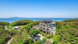 una vista aérea de una casa en una colina junto al océano en Yeongheungdo noeul&bada pension, en Incheon
