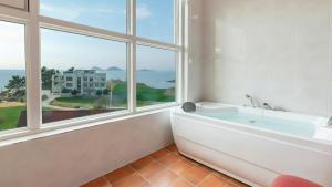 un bagno con vasca e una grande finestra di Buan TomynSpa Pension a Buan Altre 15 foto