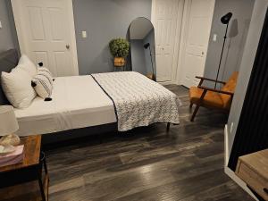 a bedroom with a bed with white sheets and wooden floors at Beautiful newly designed Luxurious Apartment in Windsor